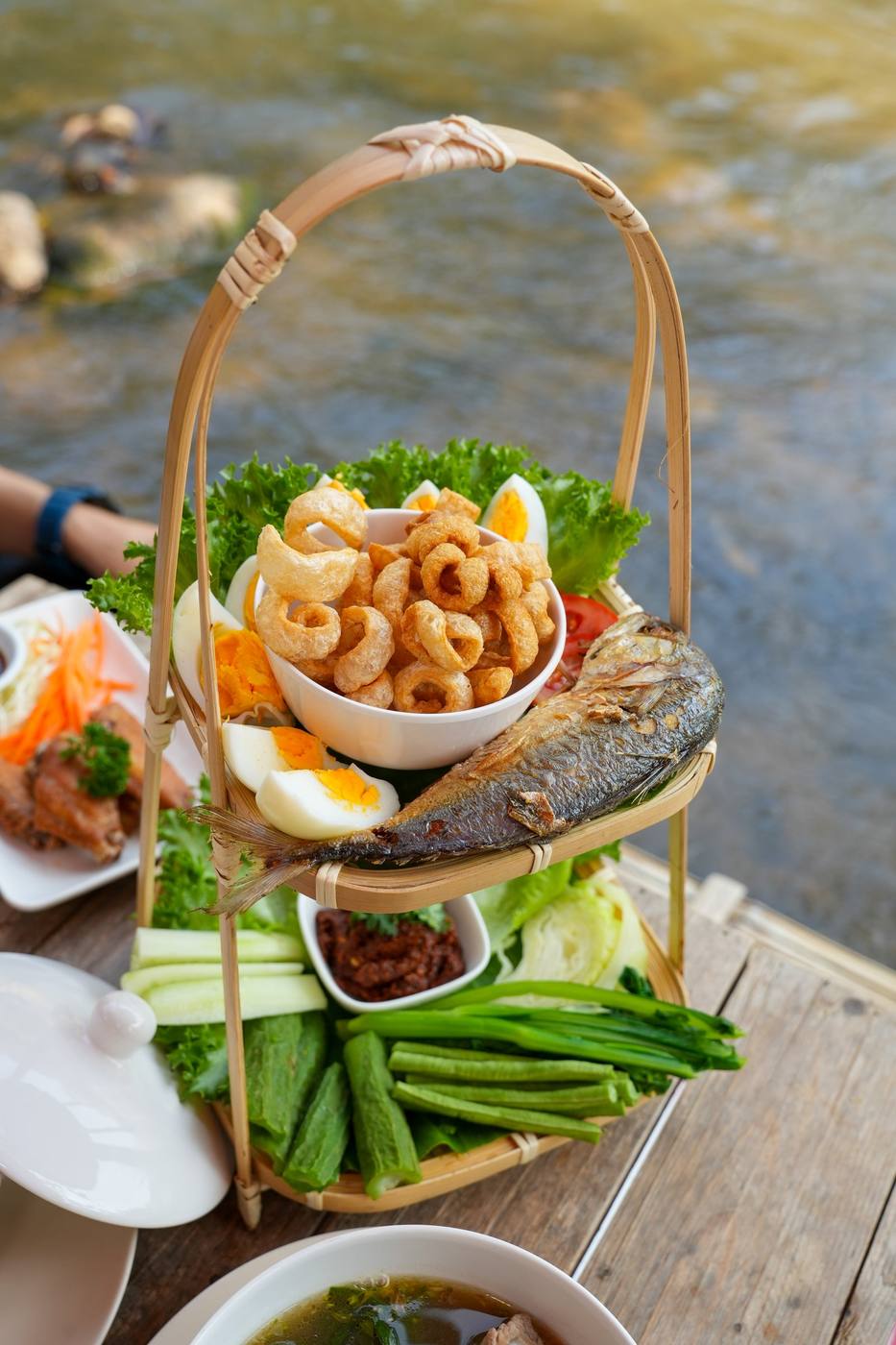 ชุดน้ำพริกอ่อง แคบหมู ปลาทู ผักสด ในตะกร้า ริมลำธาร แม่ริม